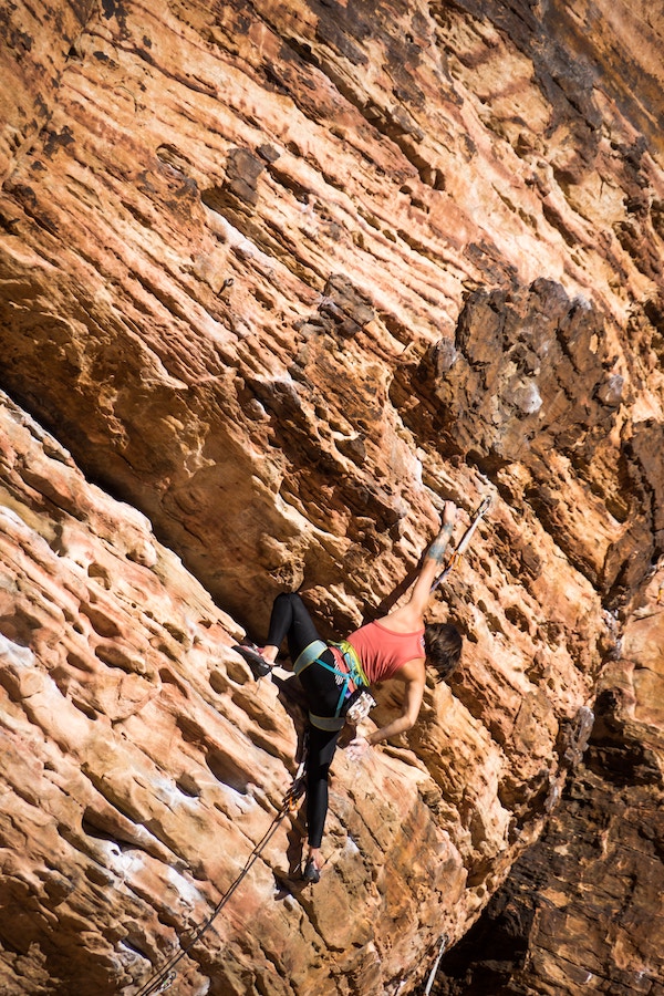 woman climbing rocky mountain